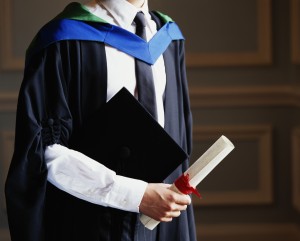 Male graduate holding certificate, mid section